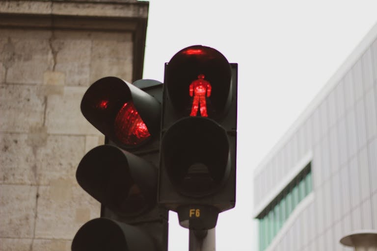 Red traffic light in Berlin with urban architecture backdrop.
