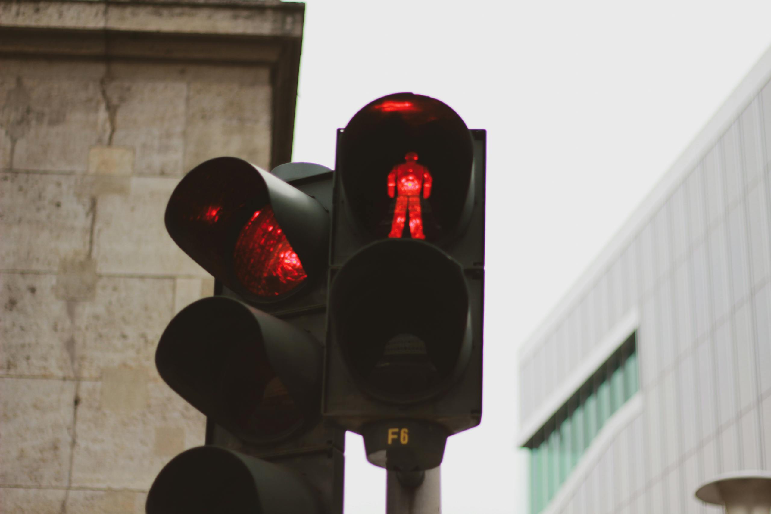 Red traffic light in Berlin with urban architecture backdrop.